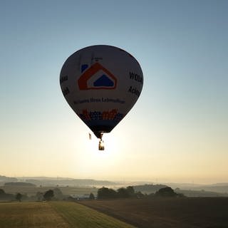 Ein Heißluftballon startet in den Sonnenaufgang