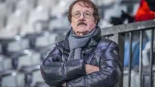 Eberhard Fugmann steht mit Daunenjacke und verschränkten Armen im Stadion.