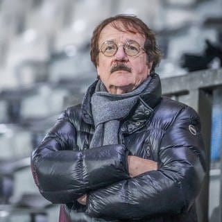 Eberhard Fugmann steht mit Daunenjacke und verschränkten Armen im Stadion.