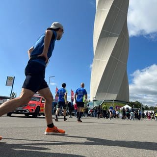 Ein Läufer macht sich warm, bevor er die Treppen des TK-Elevator-Testturms in Rottweil besteigt. Der über 230 Meter hohe Turm befindet sich im Hintergrund.