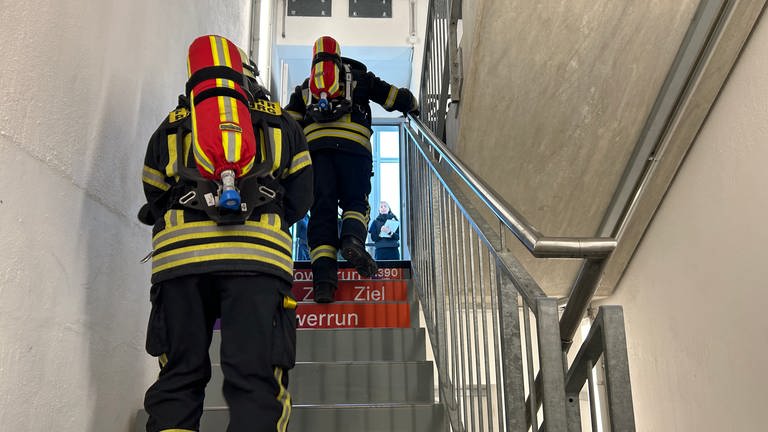 Neben dem eigenen Körpergewicht tragen die Feuerwehrmänner auch Sauerstoffflaschen hoch ans Ziel.