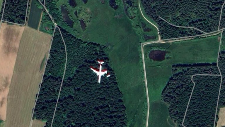 Satellitenbild von Google Maps von einer Feld- und Waldlandschaft bei Schramberg mit einem Flugzeug