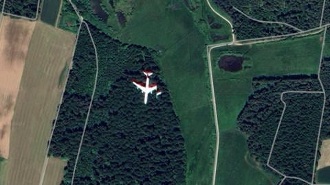 Satellitenbild von Google Maps von einer Feld- und Waldlandschaft bei Schramberg mit einem Flugzeug