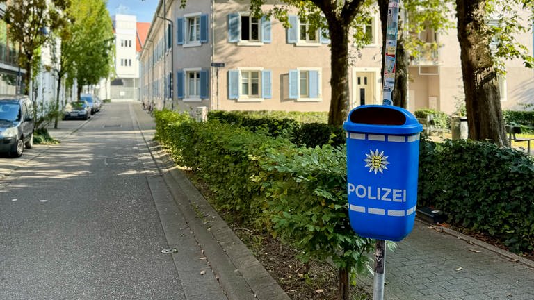 Blauer Mülleimer mit Polizei-Logo in der Nähe des Grethergeländes im Stühlinger