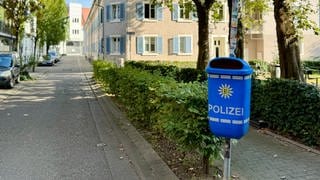 Blauer Mülleimer mit Polizei-Logo in der Nähe des Grethergeländes im Stühlinger