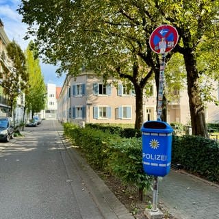 Blauer Mülleimer mit Polizei-Logo in der Nähe des Grethergeländes im Stühlinger