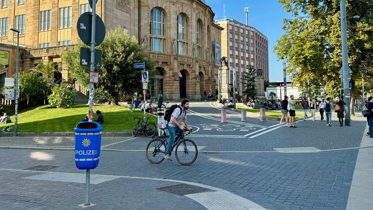 Blauer Mülleimer mit Polizei-Logo nahe der Universitätsbibliothek Freiburg