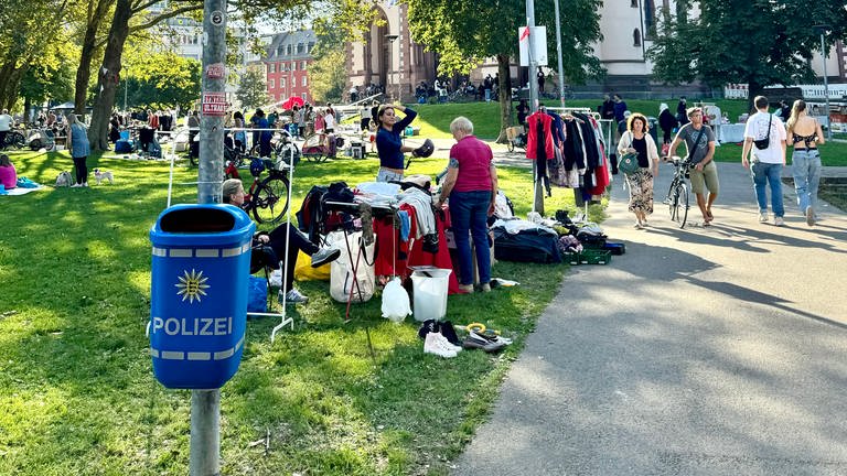 Blauer Mülleimer mit Polizei-Logo am Stühlinger Kirchplatz 