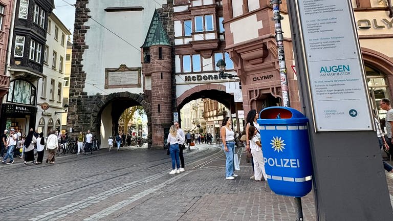 Blauer Mülleimer mit Polizei-Logo in der Freiburger Innenstadt