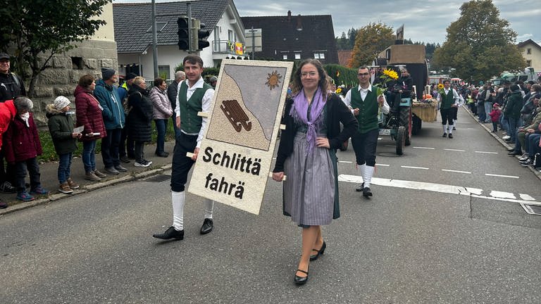 Ein Mann und eine Frau aus der Landjugend präsentieren ihr Kunstwerk, das sie zum Erntedankfest angefertigt haben.