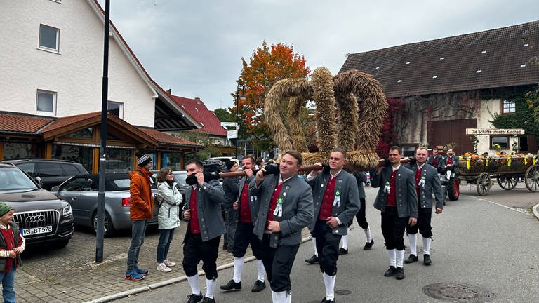 Acht junge Männder der Landjugend Brigachtal tragen für den Erntedankumzug eine Krone aus Stroh.