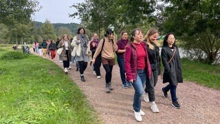 "Freiburg girls walking talking": Frauen laufen gemeinsam an der Dreisam.