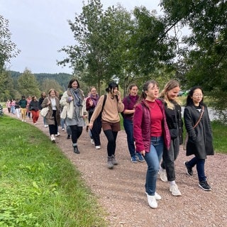 "Freiburg girls walking talking": Frauen laufen gemeinsam an der Dreisam.