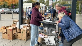 Vor einem Supermarkt stehen volle Einkaufswägen. Darin Spenden für die Menschen in der Ukraine. Darunter Windeln und lange haltbare Lebensmittel wie Mehl und Zucker.