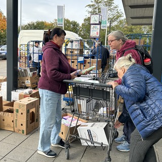 Vor einem Supermarkt stehen volle Einkaufswägen. Darin Spenden für die Menschen in der Ukraine. Darunter Windeln und lange haltbare Lebensmittel wie Mehl und Zucker.