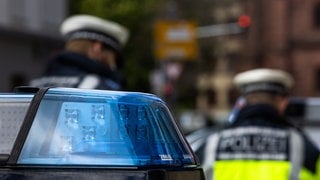 Zwei Polizeibeamte stehen zwischen zwei Einsatzfahrzeugen der Polizei. Bei einem Unfall am Samstag auf der B3 bei Bad Krozingen (Kreis Breisgau-Hochschwarzwald) kam eine 63-jährige Frau ums Leben.