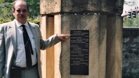 Gedenkstein auf dem jüdischen Friedhof. Dr. René Wolff-Tassano zeigt auf den Namen seiner Großmutter Rosa "Renle" Wolff. 