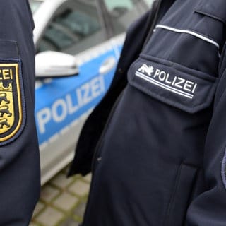 Auf den Armen von zwei  Polizeibeamten sind die Wappen der BW-Polizei zu sehen.