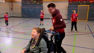 Yannick Adler in einer Sporthalle mit Kindern mit und ohne Behinderung