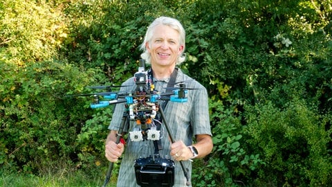 Der Biologe Andrew Straw steht mit seiner Drohne auf einem Feld bei Freiburg, um Bienen im Flug zu verfolgen.