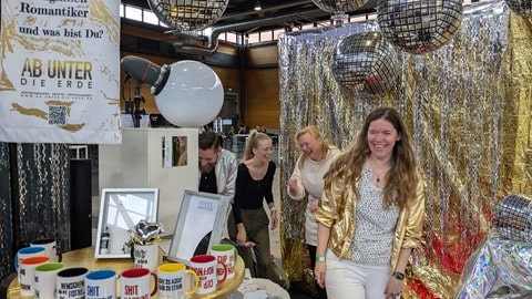 Katja Heitzmann und ihre Tochter Gina Grathwol lachen in der Fotobox beim Messestand des Bestatters "Ab unter die Erde"