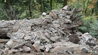 Ein Mitarbeiter der Spreng-Firma kontrolliert den gesprengten Felsen.