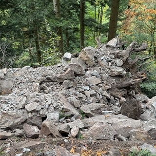 Ein Mitarbeiter der Spreng-Firma kontrolliert den gesprengten Felsen.