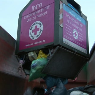 Ein Altkleidercontainer wird in Freiburg geleert.