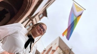 Lucy Wagner vor der Anpassung ihres Geschlechts und ihres Vornamens unter einer Regenbogenfahne am Freiburger Rathaus. Das neue Selbstbestimmungsgesetz macht solche Änderungen nun leichter. 