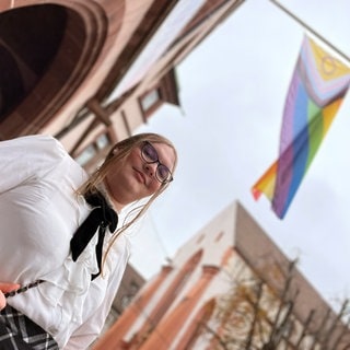 Lucy Wagner vor der Anpassung ihres Geschlechts und ihres Vornamens unter einer Regenbogenfahne am Freiburger Rathaus. Das neue Selbstbestimmungsgesetz macht solche Änderungen nun leichter. 