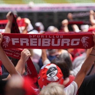 SC-Fans auf der Tribüne. Vor dem Spiel halten viele ihre Schals in die Höhe. Der Fanbeirat hat sich bei Heimspielen eine sachlichere Stadionmoderation gewünscht.