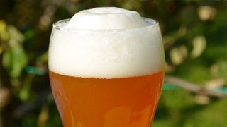 Ein Weizenbierglas mit Schaumkrone