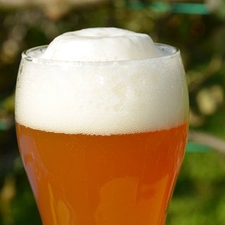 Ein Weizenbierglas mit Schaumkrone