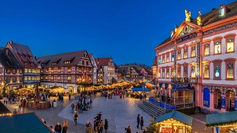 Der historische Adventskalender am Rathaus in Gengenbach. Drumherum stehen Weihnachtsmarkt-Buden. 