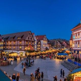 Der historische Adventskalender am Rathaus in Gengenbach. Drumherum stehen Weihnachtsmarkt-Buden. 