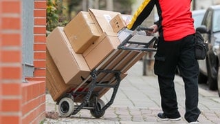 Ein Postbote stellt Pakete zu. In Rheinfelden soll ein Paketzusteller ein gerade ausgeliefertes Paket entwendet haben.