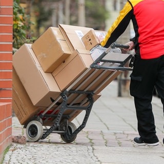 Ein Postbote stellt Pakete zu. In Rheinfelden soll ein Paketzusteller ein gerade ausgeliefertes Paket entwendet haben.