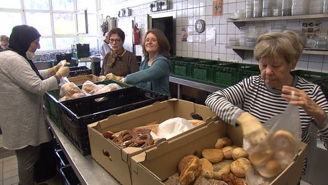 Frauen sortieren Brötchen in Tüten