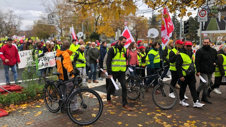 Streikende der Gewerkschaft ver.di mit Fahnen und Warnwesten.