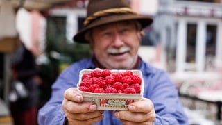 Obsthändler Walter Schwaab steht auf dem Freiburger Münsterplaz und hält eine Schale frischer Himbeeren aus der Region in den Händen. Trotz Herbstwetter mit einstelligen Temperaturen, Nebel und Wind wachsen in der Region Freiburg, die auch "Toskana Deutschlands" genannt wird, noch Himbeeren. 