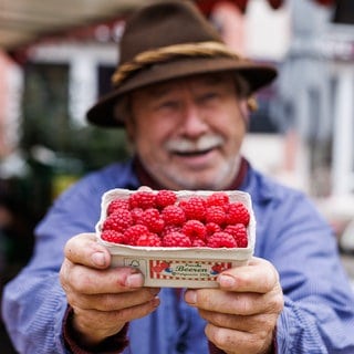 Obsthändler Walter Schwaab steht auf dem Freiburger Münsterplaz und hält eine Schale frischer Himbeeren aus der Region in den Händen. Trotz Herbstwetter mit einstelligen Temperaturen, Nebel und Wind wachsen in der Region Freiburg, die auch "Toskana Deutschlands" genannt wird, noch Himbeeren. 