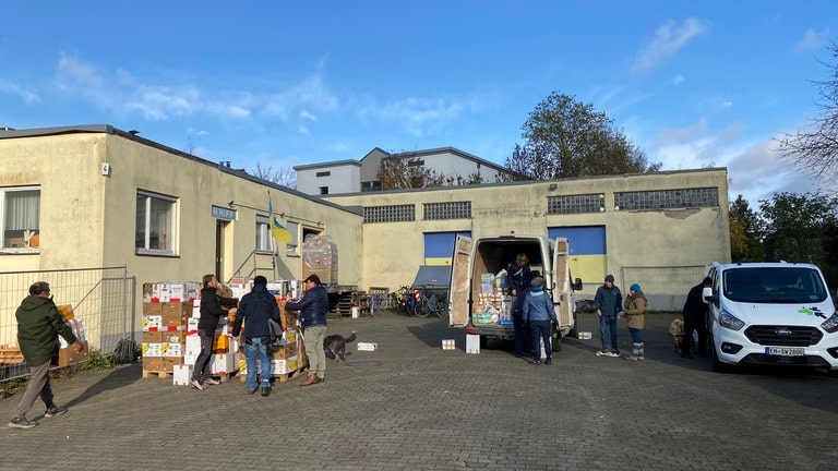 Auf einem Hof in Merzhausen bei Freiburg werden die Waren für den Hilfskonvoi in die Ukraine in Transporter und Anhänger gepackt.