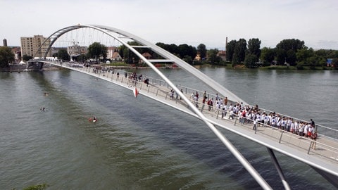 Menschen überqueren zu Fuß die Dreiländerbrücke in Weil am Rhein.