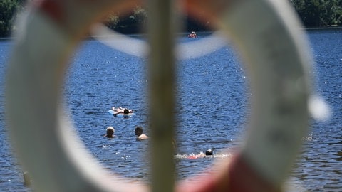 Schwimmer kühlen sich im Titisee in der Nähe einer Rettungsstation ab.