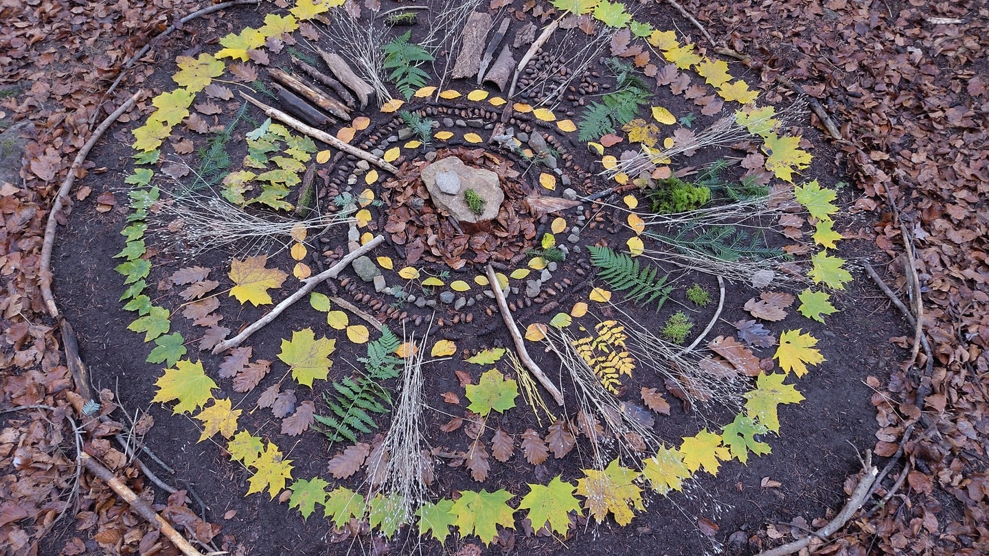 ein Mandala, gelegt aus buntem Herbstlaub