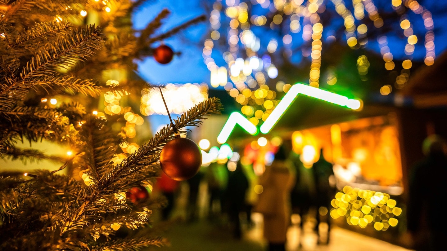 Eine Christbaumkugel hängt an einem Baum auf dem Freiburger Weihnachtsmarkt.