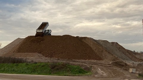 Einer von etwa 30 Lkw, die täglich zum Zwischenlager fahren, lädt Erde ab. Seit 2021 hat die Stadt Freiburg schon 360.000 Tonnen Erdaushub eingelagert.