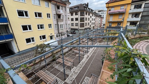 Ein Platz mit leeren Bänken an der Ecke eines Parks in Freiburg