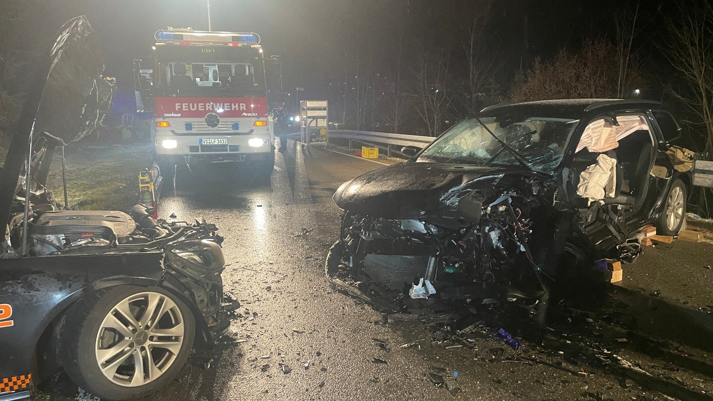 Zwei Autos sind auf einer Landstraße frontal zusammengeprallt, die Feuerwehr und Polizei haben die Straße abgesperrt.