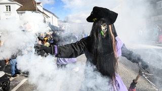 Ein Rhinwaldgeist aus Kehl hält beim Umzug der Bauernfastnacht einen Rauchtopf in der Hand